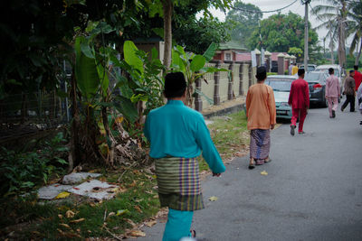Rear view of people walking on footpath