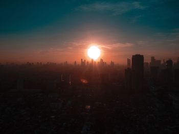 Silhouette buildings against sky during sunset
