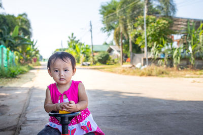 Portrait of cute girl standing on road