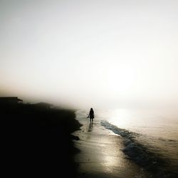 Silhouette people on calm beach