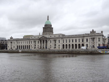 Buildings in city against cloudy sky