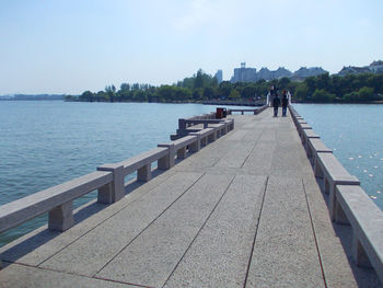 Footbridge over river against clear sky