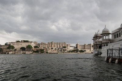 View of buildings in city against cloudy sky