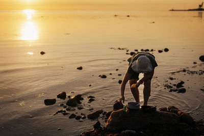 Woman washing dishes at sea