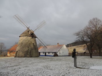 Traditional windmill on field against sky