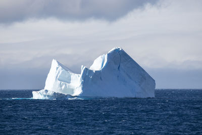 Floating icberg in the sun isolated on dramatic sky