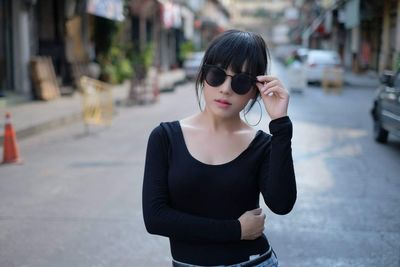 Young woman standing on street in city