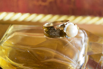 Close-up of pearl ring on perfume bottle