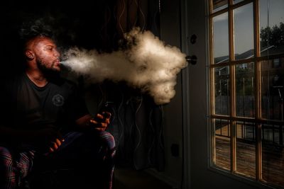 Man smoking cigarette while sitting at home