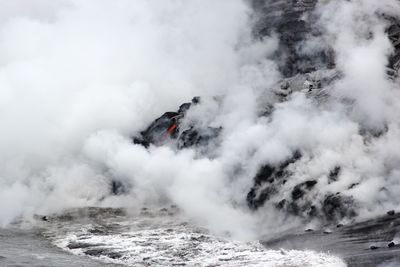 Smoke erupting from volcano at coastline