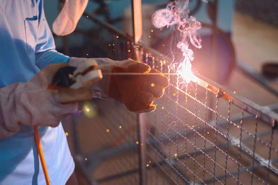 Midsection of man working on metal