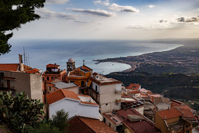 High angle view of houses and sea against sky 