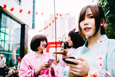 Portrait of smiling woman holding mobile phone