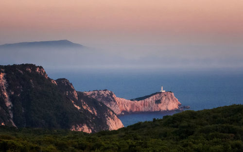 Scenic view of sea and mountains against sky