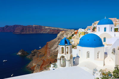 Panoramic view of buildings against clear blue sky