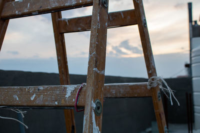 Close-up of rusty metallic structure against sky