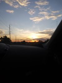 Silhouette car on road against sky during sunset