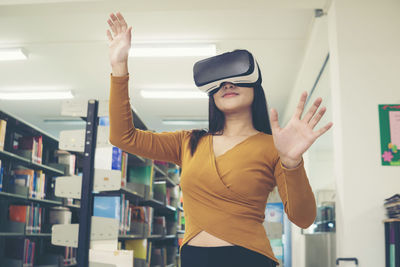 Young woman gesturing while wearing virtual reality simulator