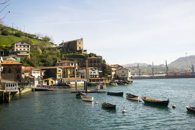 Boats in river with buildings in background