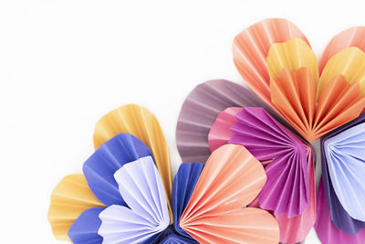 Multi-colored paper origami hearts arranged to make flower design