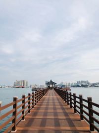 Empty pier over sea against sky