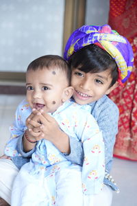 Portrait of cute baby boy lying on bed at home