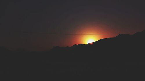 Scenic view of silhouette mountain against sky at sunset