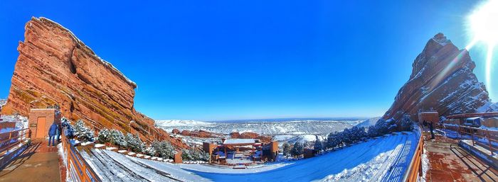 Panoramic view of snow covered red rocks ampitheatre against blue sky