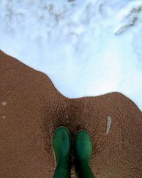 Low section of person legs on sand at beach