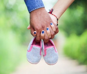 Cropped couple holding baby booties