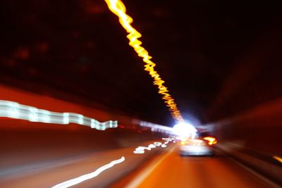 Light trails on road in city against sky at night