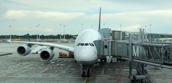 Airplane on airport runway against sky