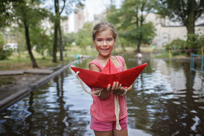 Portrait of smiling girl standing on lake