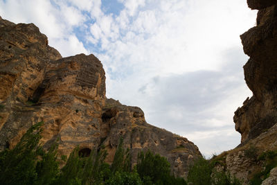 Low angle view of rocky mountains against sky