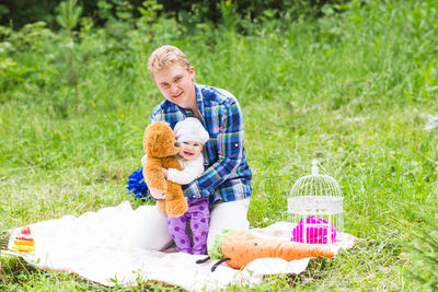 Side view of a smiling boy toy on grass