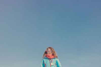 Portrait of girl against blue sky