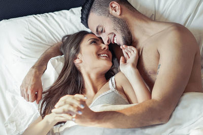 Smiling young couple romancing on bed
