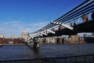 Bridge over river in city against sky