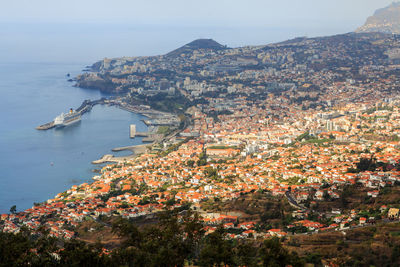 High angle view of townscape by sea against sky