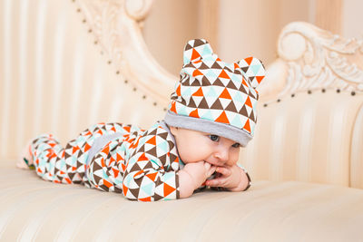 Baby girl lying on bed at home