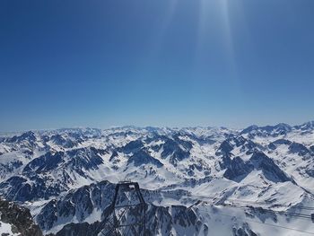 Scenic view of snowcapped mountains against blue sky