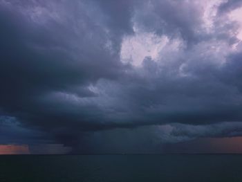 Scenic view of sea against storm clouds