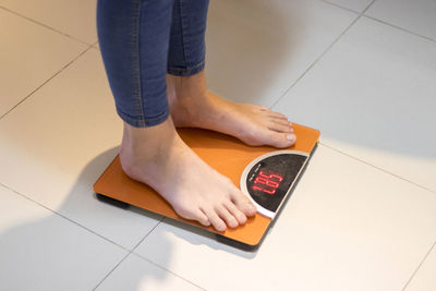 Low section of man standing on tiled floor