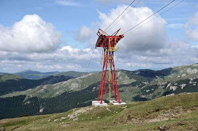 Traditional windmill on mountain against sky