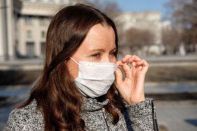 Close-up of woman wearing scarf and knit hat outdoors during winter