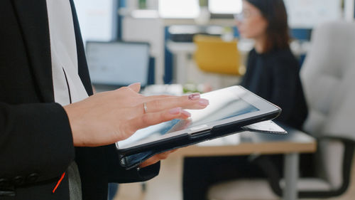 Midsection of businesswoman using digital tablet