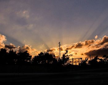 Silhouette trees against scenic sky