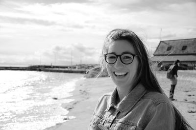 Portrait of smiling young woman standing at beach