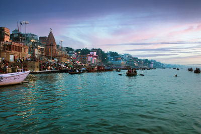 Boats in sea against buildings in city