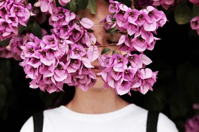 Close up of young woman with eyes closed standing pink flowers